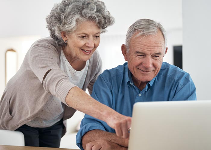 Image of couple looking at a laptop.